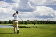Male golf player teeing off golf ball from tee box
