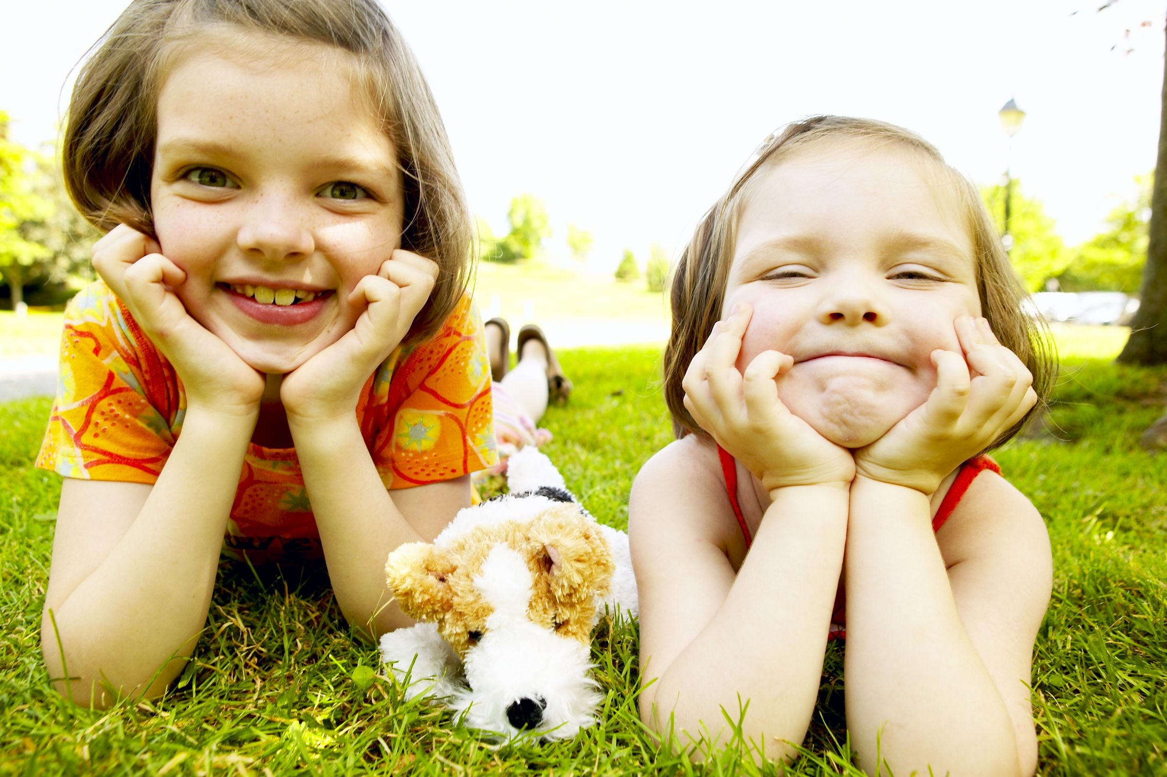 two girls laying in grass