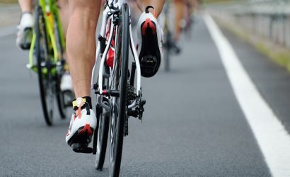 View of cyclists feet and bike wheels on the road