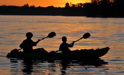 two people kayaking at sunset