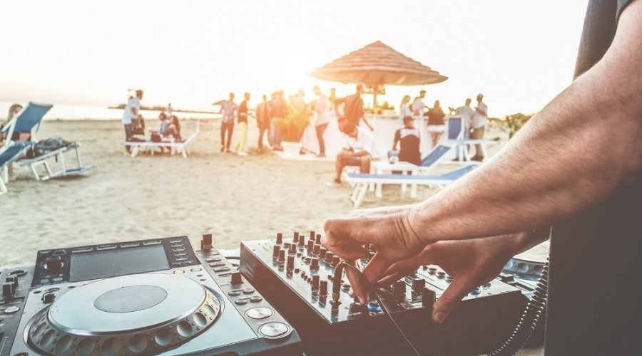 DJ playing on beach for crowd