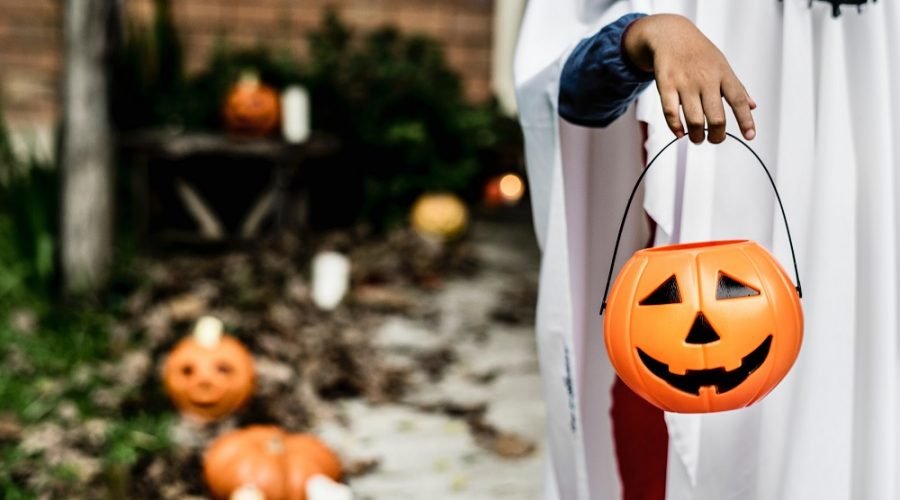 child carrying halloween pumpkin bucket