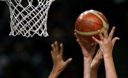 close up of basketball net with hands grabbing basketball