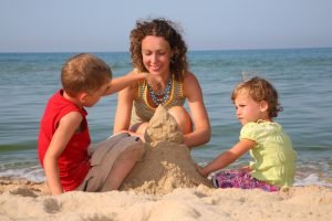 mother and children making sand castle on the beach