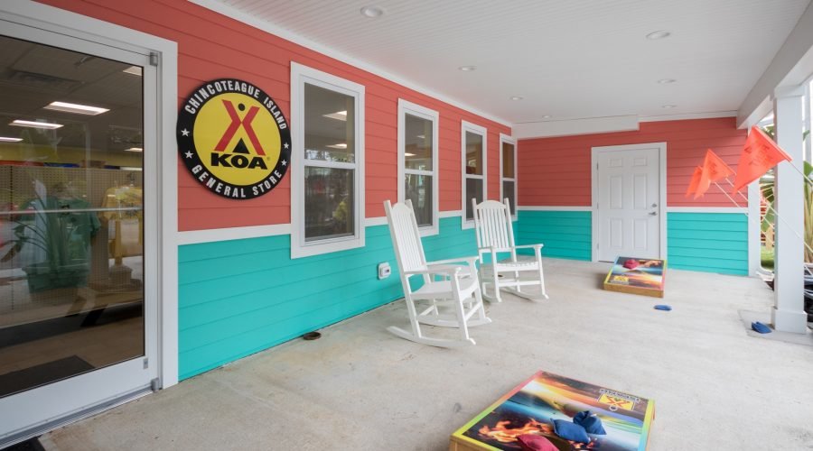 Chincoteague Island KOA General Store with bag toss game in front of bright coral and teal building