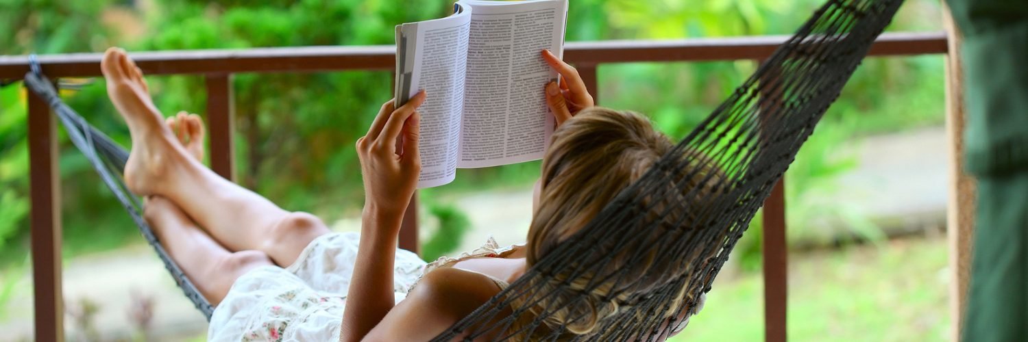 woman reading a book in a hammock