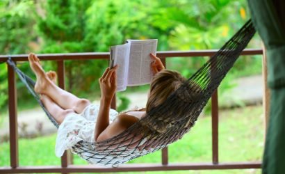 woman reading a book in a hammock