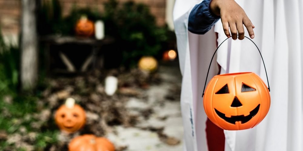 child carrying halloween pumpkin bucket