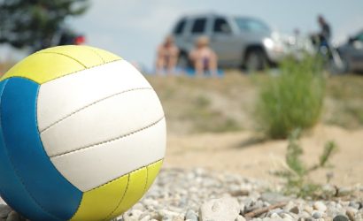 red white blue volleyball outside on a bed of gravel