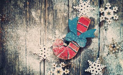 a handmade wooden candy cane and snowflakes on distressed wood background
