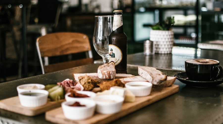 restaurant table set with cheese board and bottled beer